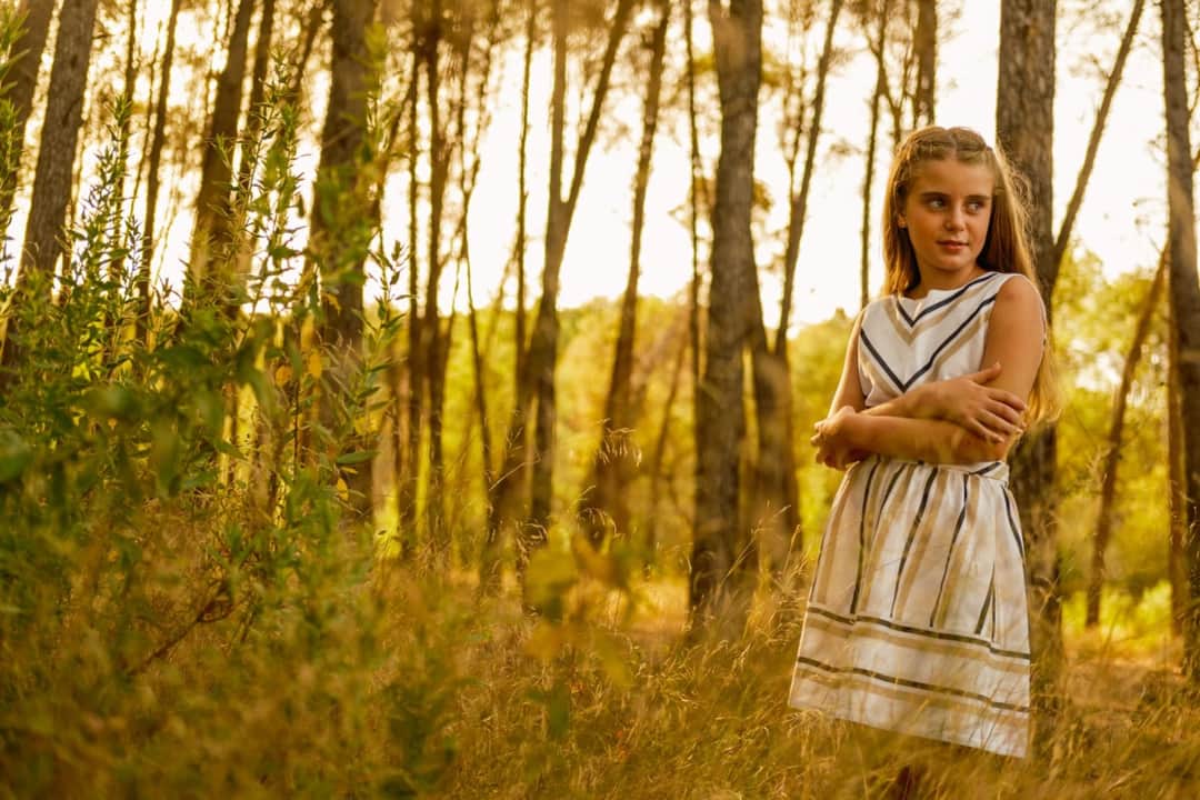 Fotografía de una niña pequeña en su comunión mirando hacia el lado en el campo en Granada