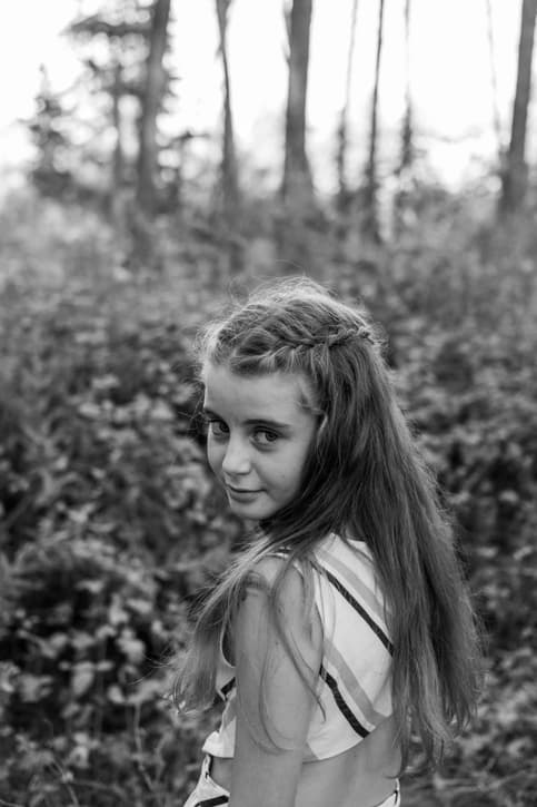Fotografía en blanco y negro de una niña pequeña en su comunión mirando de lado a la cámara en Granada