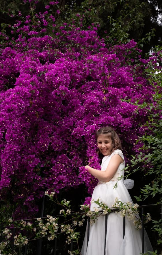 Fotografía de una niña de comunión abrazando unas flores