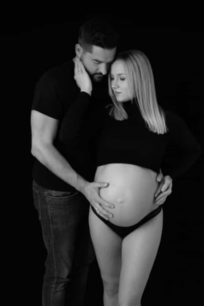 Pareja posando juntos en una sesión de fotos de embarazo