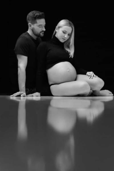 Pareja posando juntos mientras se hacen fotos de embarazada
